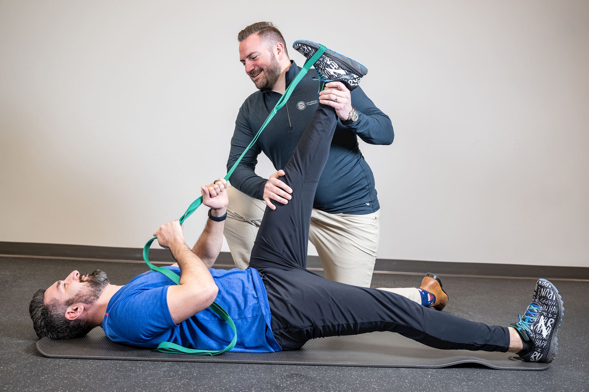physical therapist assisting patient in performing stretching exercises