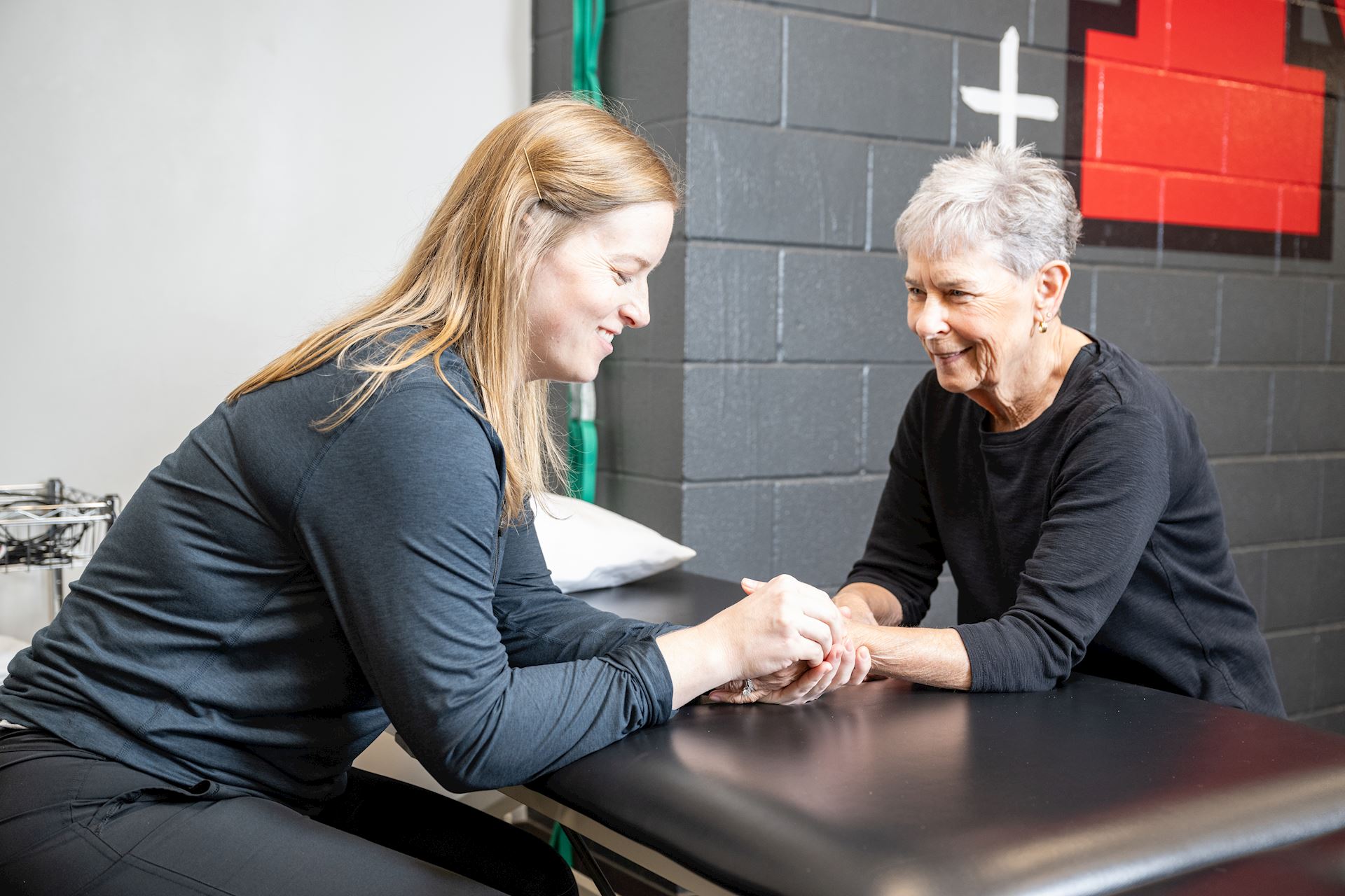 physical therapist conducting hand therapy with an elderly female patient